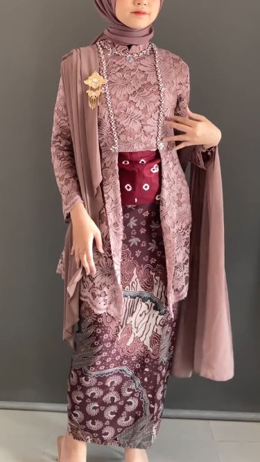 Wanita memakai kebaya brokat modern pastel ungu muda dengan kain batik dan hijab