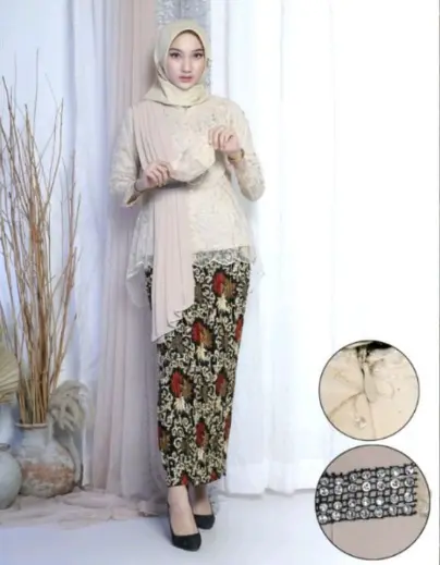 Wanita memakai kebaya modern krem dengan rok batik